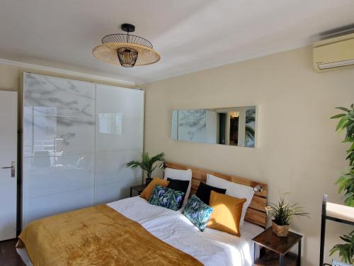 a bedroom with a bed with pillows on it at La PerleCanet - vue mer au centre in Canet-en-Roussillon