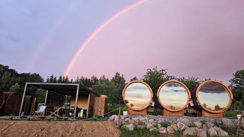 een regenboog in de lucht boven een groep houten bollen bij Czill Beczki in Mucharz