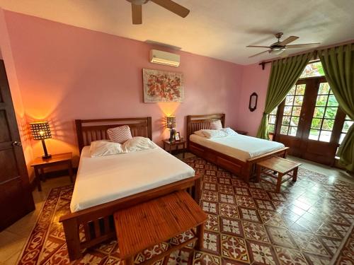 2 camas en una habitación con paredes rosas en Hotel La Polvora, en Granada