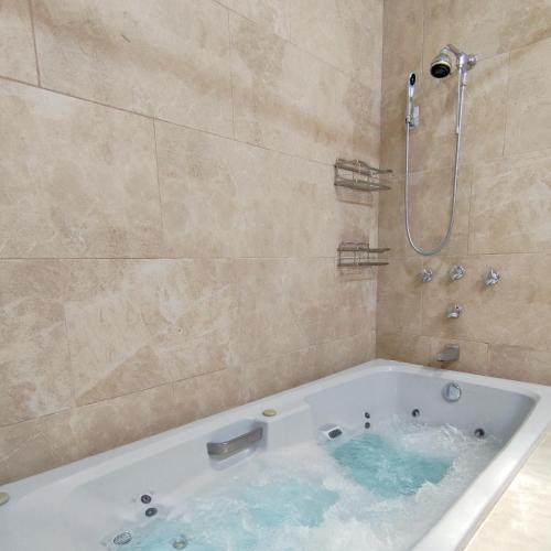 a bath tub filled with blue water in a bathroom at Colonial Villa in Merida Centro 4BR 3BA Private Pool Near Paseo de Montejo in Mérida
