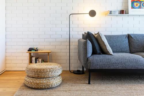 a living room with a blue couch and a lamp at S1405 - practical and modern - AC, balcony and parking in Porto