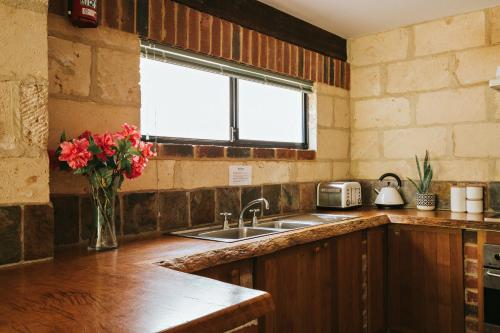 a kitchen with a sink and a vase of flowers at By the Sea Margaret River in Gnarabup