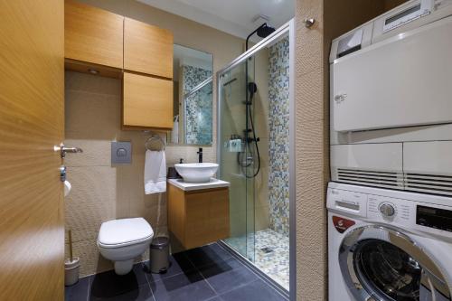 a bathroom with a toilet and a washing machine at Apartment in Downtown Reykjavík in Reykjavík