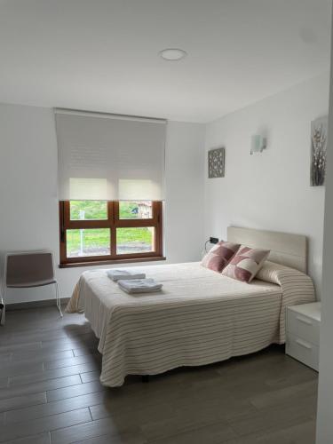 Un dormitorio blanco con una cama grande y una ventana en Apartamento Rústico en Ochandiano