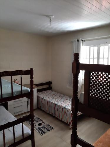 a bedroom with two bunk beds and a window at Chácara da Madrinha in Guarapari
