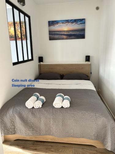 - un lit avec 2 paires de chaussons dans l'établissement Cosy studio proche de la Défense Arena, à La Garenne-Colombes