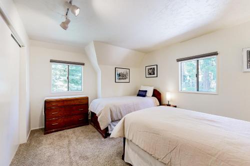 ein Schlafzimmer mit zwei Betten und zwei Fenstern in der Unterkunft Natures Reserve in Lake Arrowhead