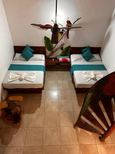a room with two beds and a ceiling fan at hotel montana Doradal in Doradal