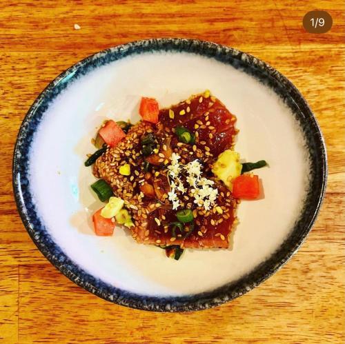 a plate of food on a wooden table at Cosy Appartement Escapade Label Braise, terrasse et parking in Ségoufielle