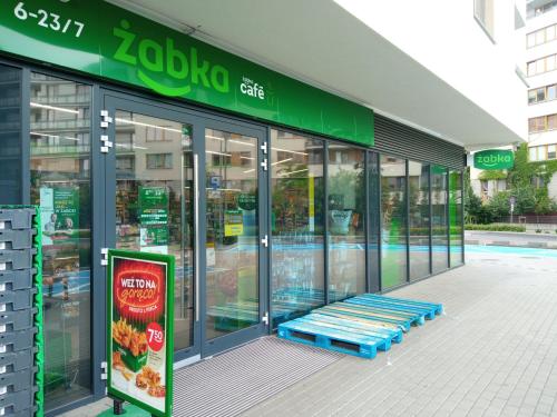 uma frente de loja com um banco azul do lado de fora em Apartamenty Bokserska em Varsóvia