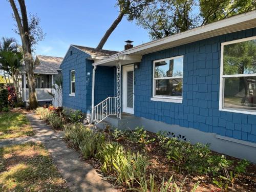 een blauw huis met een stoep ervoor bij The Little Blue House Kenwood Ping Pong Hockey Family in St Petersburg
