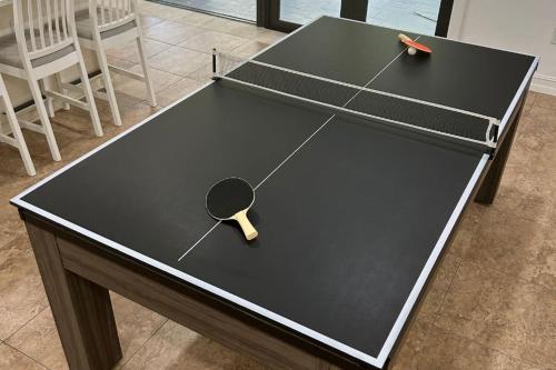 a ping pong table with a ping paddle on it at The Lake House Mia Natural Pool Wellness Center Pool Table Ping Pong Family in Homestead