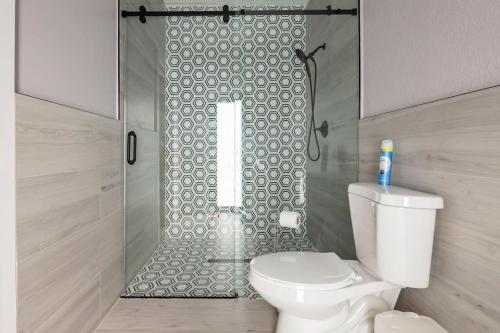 a bathroom with a toilet and a glass shower at The Lake House Mia Natural Pool Wellness Center Pool Table Ping Pong Family in Homestead