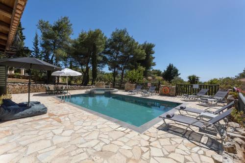 a swimming pool with lounge chairs and an umbrella at Aresti Mountain Resort in Agios Leon