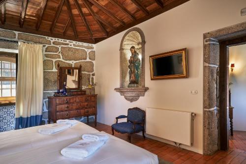 a bedroom with two beds and a tv and a chair at Solar de Vilar Seco in Vilar Seco