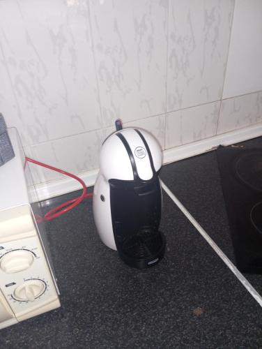 a black and white blender sitting on the floor next to a stove at Apartamento compartido comedor zona tranquila in La Línea de la Concepción