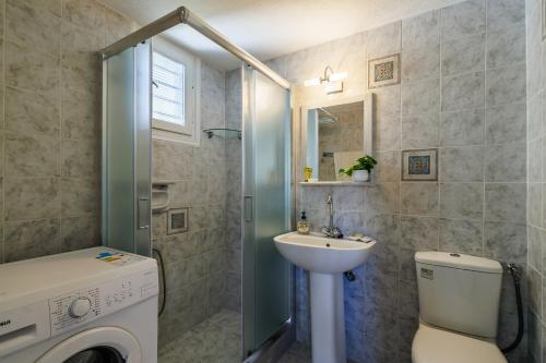 łazienka z umywalką i pralką w obiekcie Anesis Apartment 2 Fireplace w mieście Skopelos