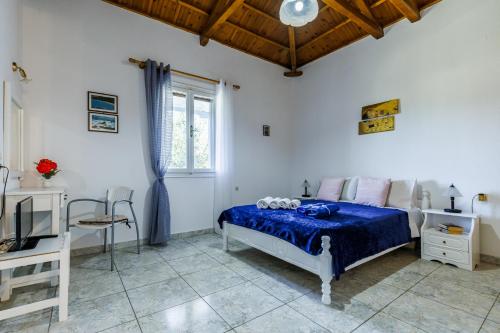 sypialnia z niebieskim łóżkiem i oknem w obiekcie Anesis Apartment 2 Fireplace w mieście Skopelos