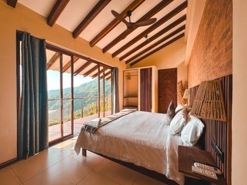 a bedroom with a bed and a large window at Villa Canopy Minca in Minca