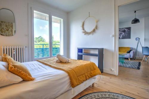 une chambre avec un grand lit avec une grande fenêtre dans l'établissement Le balcon de la Cathédrale, à Périgueux