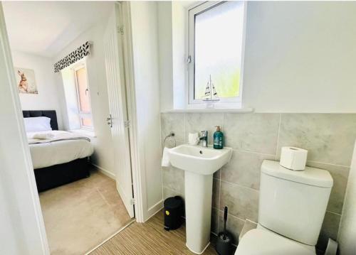 アシュフォードにあるAshford Retreat - Luxury Home with Double Parkingのトイレ、洗面台、ベッドのあるバスルーム