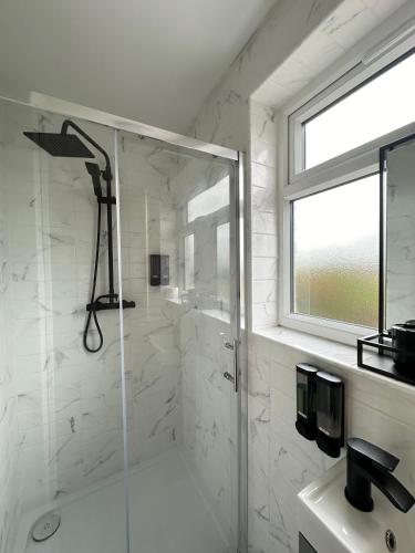 a bathroom with a shower with a glass door at Sun Guest House Cambridge in Cambridge