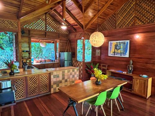 コクレスにあるGeckoes Lodgeのキッチン(木製テーブル、緑の椅子付)
