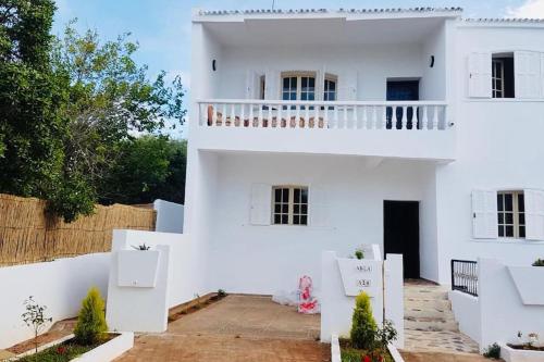 a white house with a balcony on top of it at Villa David front de mer in Bouznika