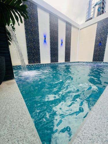 a swimming pool with a fountain in a building at Casita ni Raphaella in Tacloban