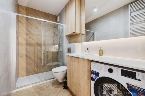 a bathroom with a toilet and a washing machine at Diasfera Prestige by LookAp in Łódź