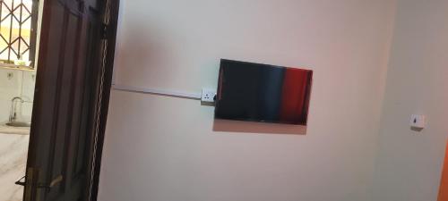 a flat screen tv on a wall in a room at Agréable séjour in Accra