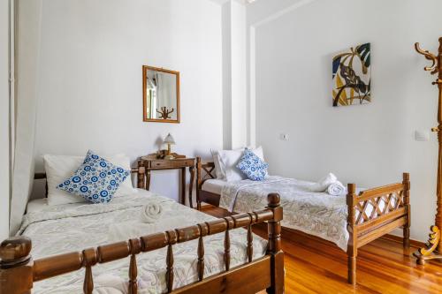 a bedroom with two beds and a mirror at Sofia's House - Skopelos Town in Skopelos Town