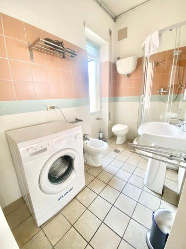 a bathroom with a washing machine and a toilet at Il Viaggiatore Serapo in Gaeta