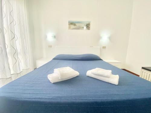 two white towels sitting on a blue bed at Il Viaggiatore Serapo in Gaeta