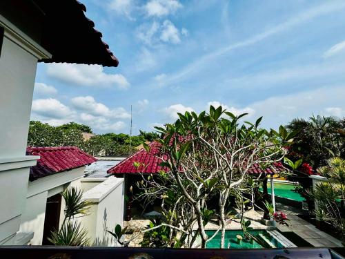 a view from the balcony of a house with a tree at Jimbaran Cozy Stay in Jimbaran