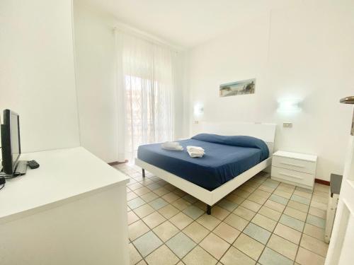a bedroom with a blue bed in a white room at Il Viaggiatore Serapo in Gaeta