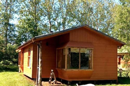 a small wooden cabin with a window in a field at Cabañas De Madera in La Unión