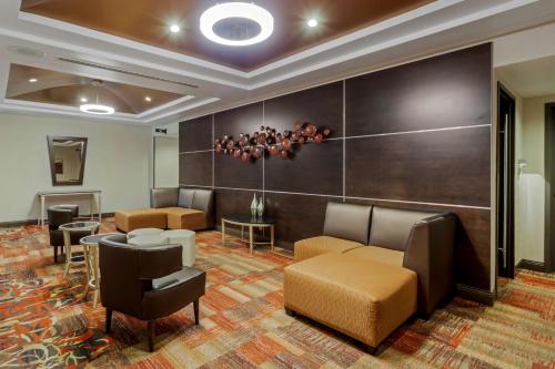 a waiting room with couches and chairs and a chandelier at Best Western Premier Denham Inn & Suites in Leduc