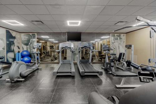 a gym with tread machines and a flat screen tv at Best Western Premier Denham Inn & Suites in Leduc