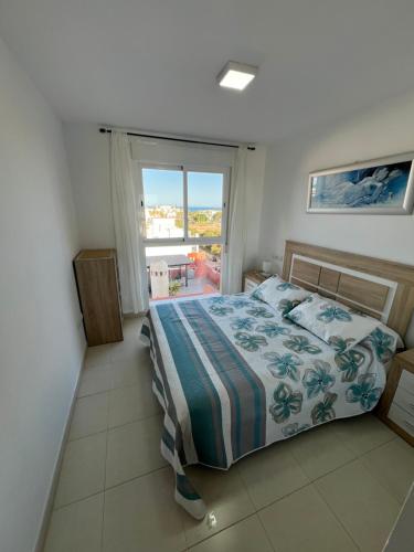 a bedroom with a bed and a large window at Ático con vistas al mar y piscina privada in Vera