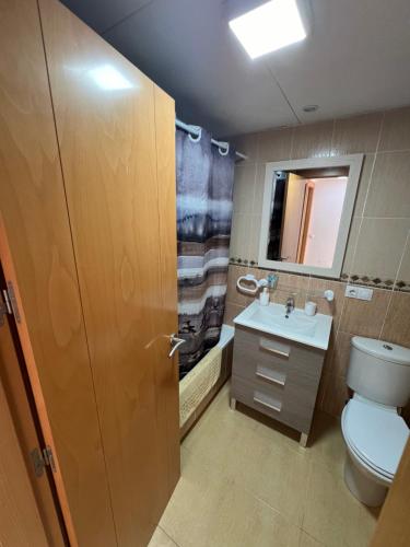 a bathroom with a toilet and a sink and a mirror at Ático con vistas al mar y piscina privada in Vera
