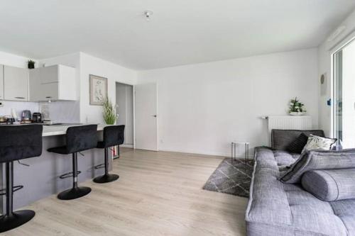 a living room with a couch and a kitchen at Résidence Abraham-Guest Room 1 LaDéfense U-Arena #Terasse #Fibre #View in Colombes