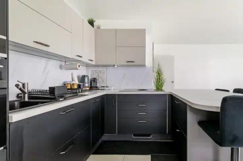 a kitchen with black and white cabinets and a sink at Résidence Abraham-Guest Room 1 LaDéfense U-Arena #Terasse #Fibre #View in Colombes