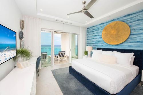 1 dormitorio con 1 cama grande y pared azul en Rum Point Resort 308, en Driftwood Village