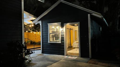 a house with a door open to a patio at night at Lovely Spacious Guesthouse in Mills 50 District in Orlando