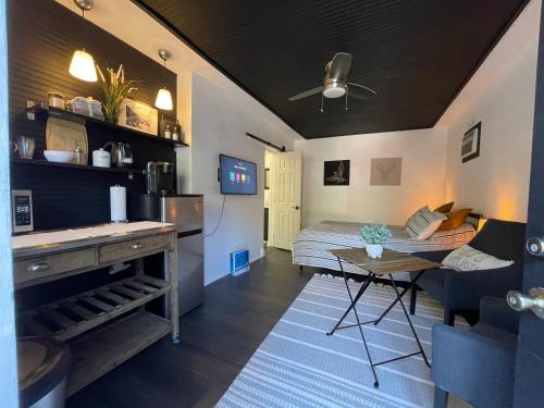a living room with a bed and a table in a room at Lovely Spacious Guesthouse in Mills 50 District in Orlando
