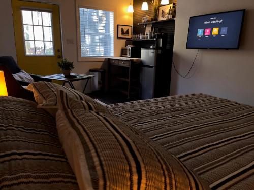 a bedroom with a bed and a flat screen tv at Lovely Spacious Guesthouse in Mills 50 District in Orlando