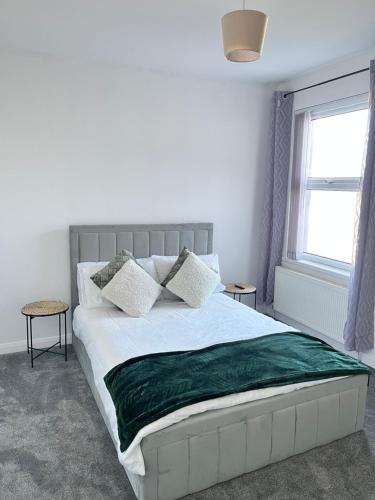 a bedroom with a bed with a green blanket on it at Ty Noah- Newly Refurbished Home In The Heart Of Pembrokeshire in Milford Haven