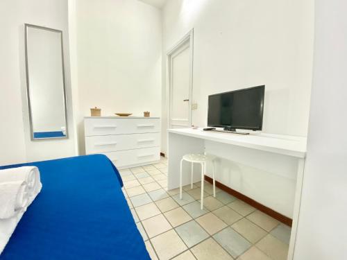 a bedroom with a bed and a desk with a tv at Il Viaggiatore Serapo in Gaeta