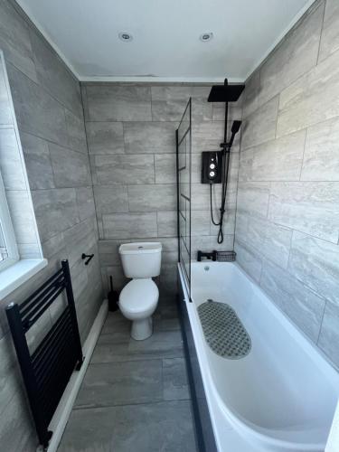 a bathroom with a toilet and a bath tub at Ty Noah- Home In The Heart Of Pembrokeshire in Milford Haven